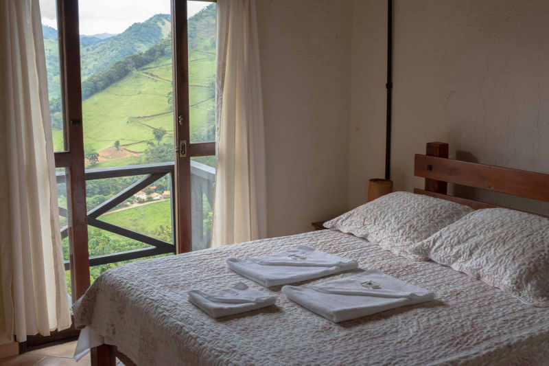 Amplo quarto com linda vista panorâmica da Serra dos Remédios.